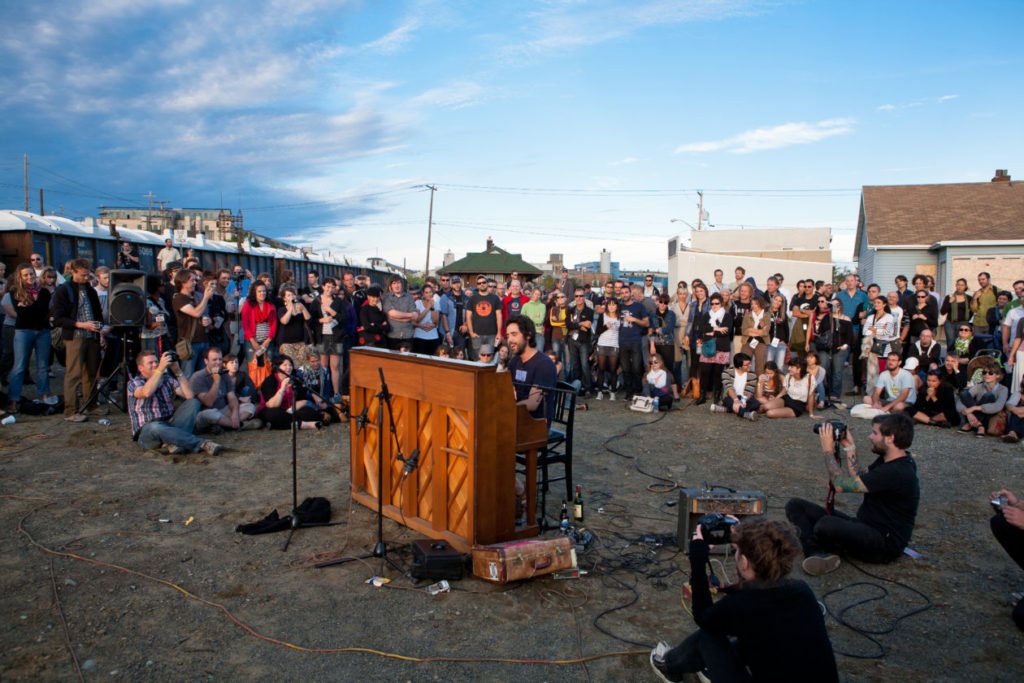 Patrick Watson devant son piano, lors d'un concert intime au FME en 2011, devant la Fonderie Horne, symbole de Rouyn-Noranda.